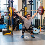 A researcher observes an athlete lifting.