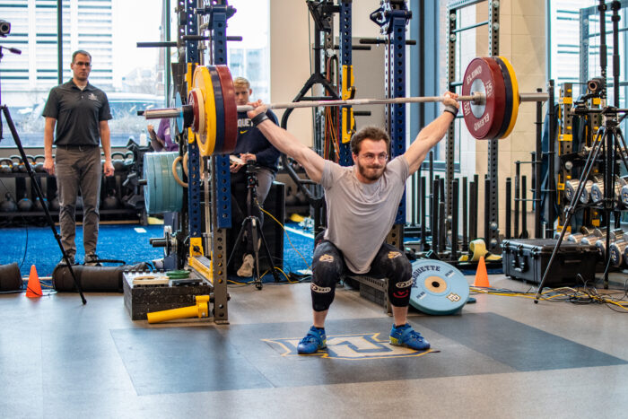 A researcher observes an athlete lifting. 