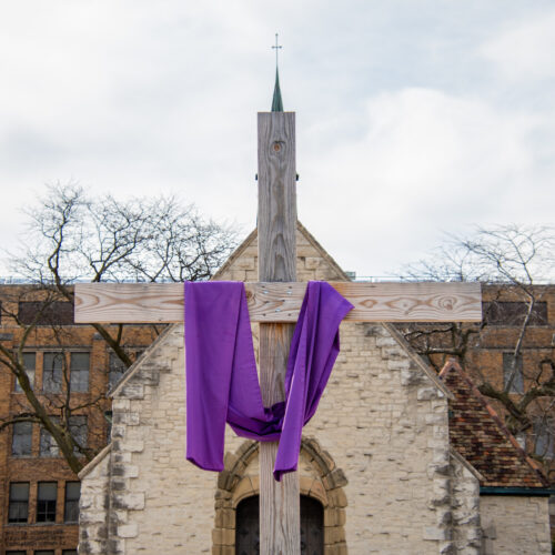 Cross with purple Lenten ribbon draped across it.