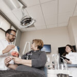 Dr. Arndt Guentsch speaks with a patient in a dental chair.