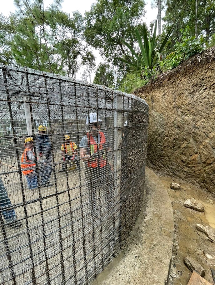 A student works on the wire foundation of a water tank.