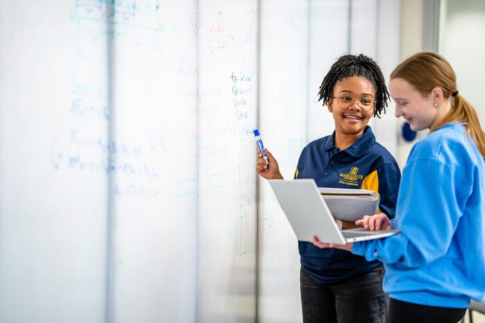 two students collaborating at a whiteboard