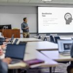 A professor teaches at the front of a classroom.