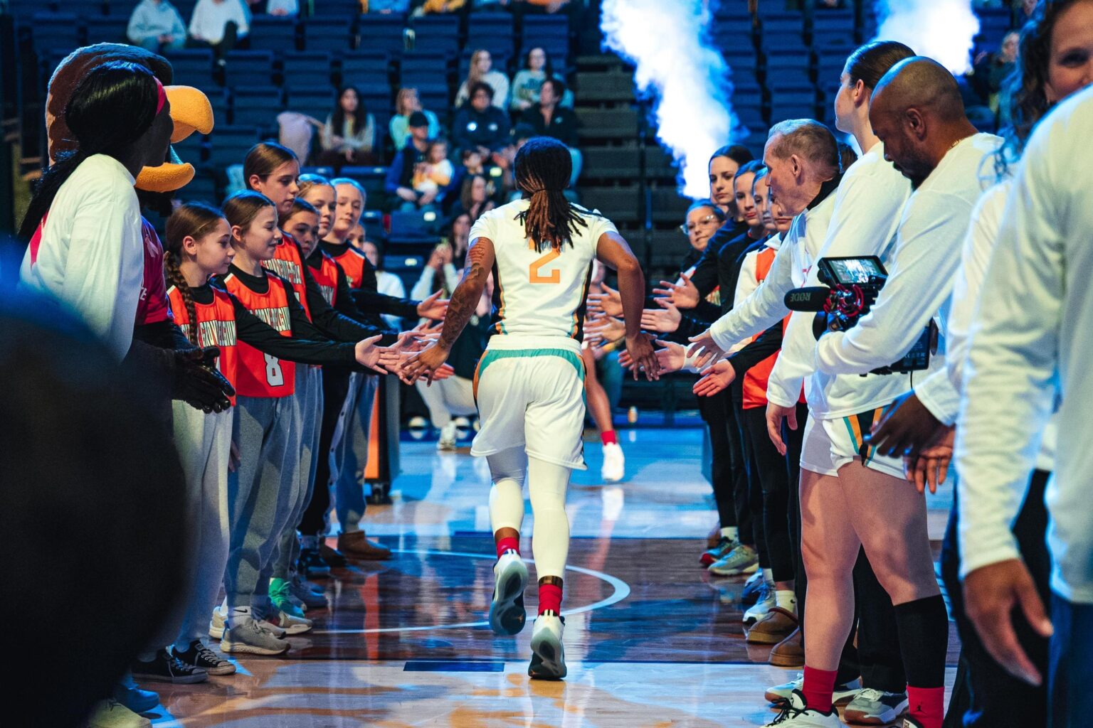 Women's basketball player Jaidynn Mason runs onto the court during player introductions.