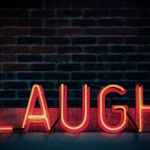 A neon sign saying "Laugh."
