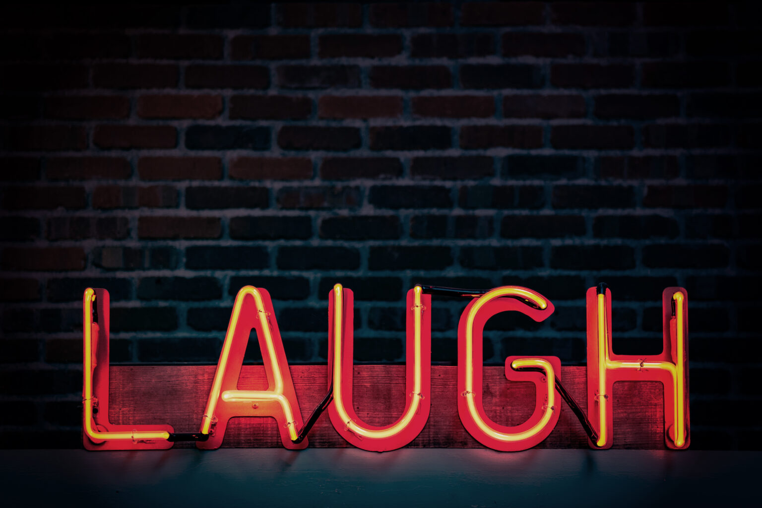 A neon sign saying "Laugh."