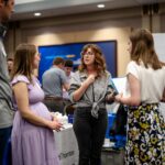A student meets with company representatives at a Career and Internship Fair.