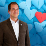 Lots of blue origami paper hearts with a red one over them