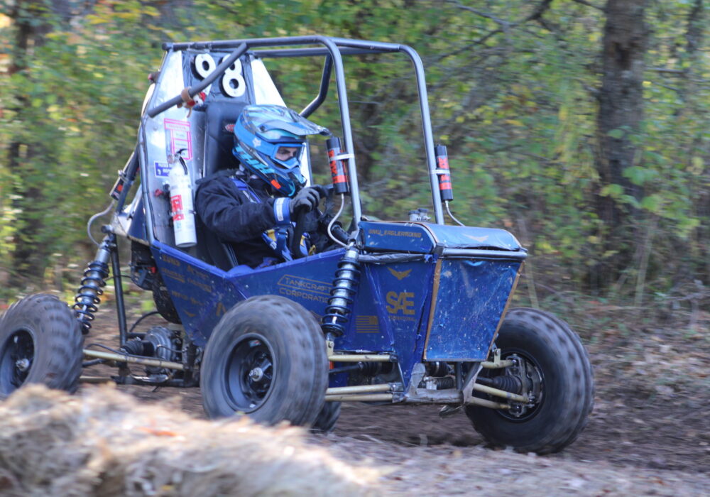 off-road racing vehicle on a dirt track through the woods