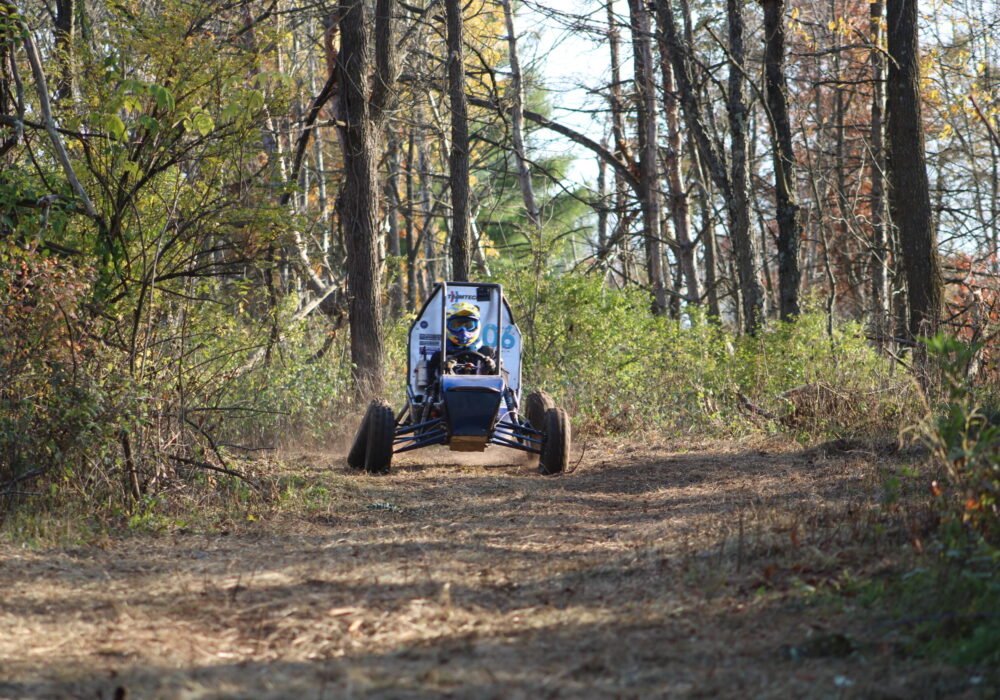 off-road racing vehicle on a dirt track through the woods