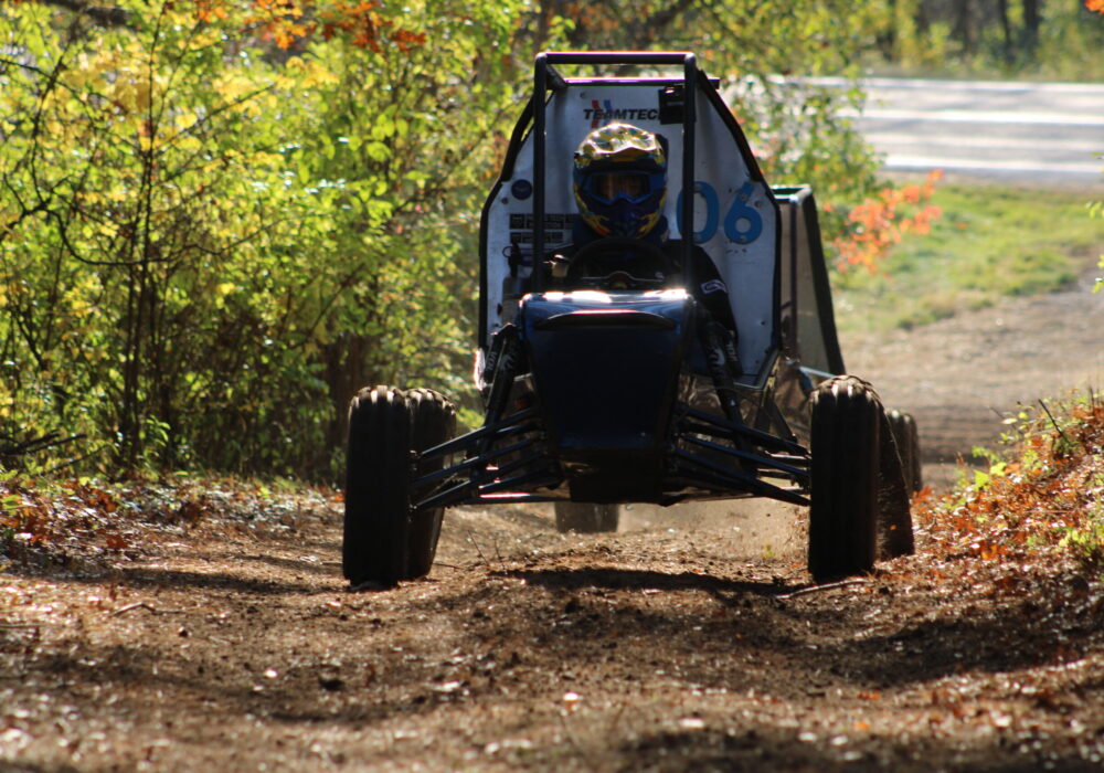 off-road racing vehicle on a dirt track through the woods
