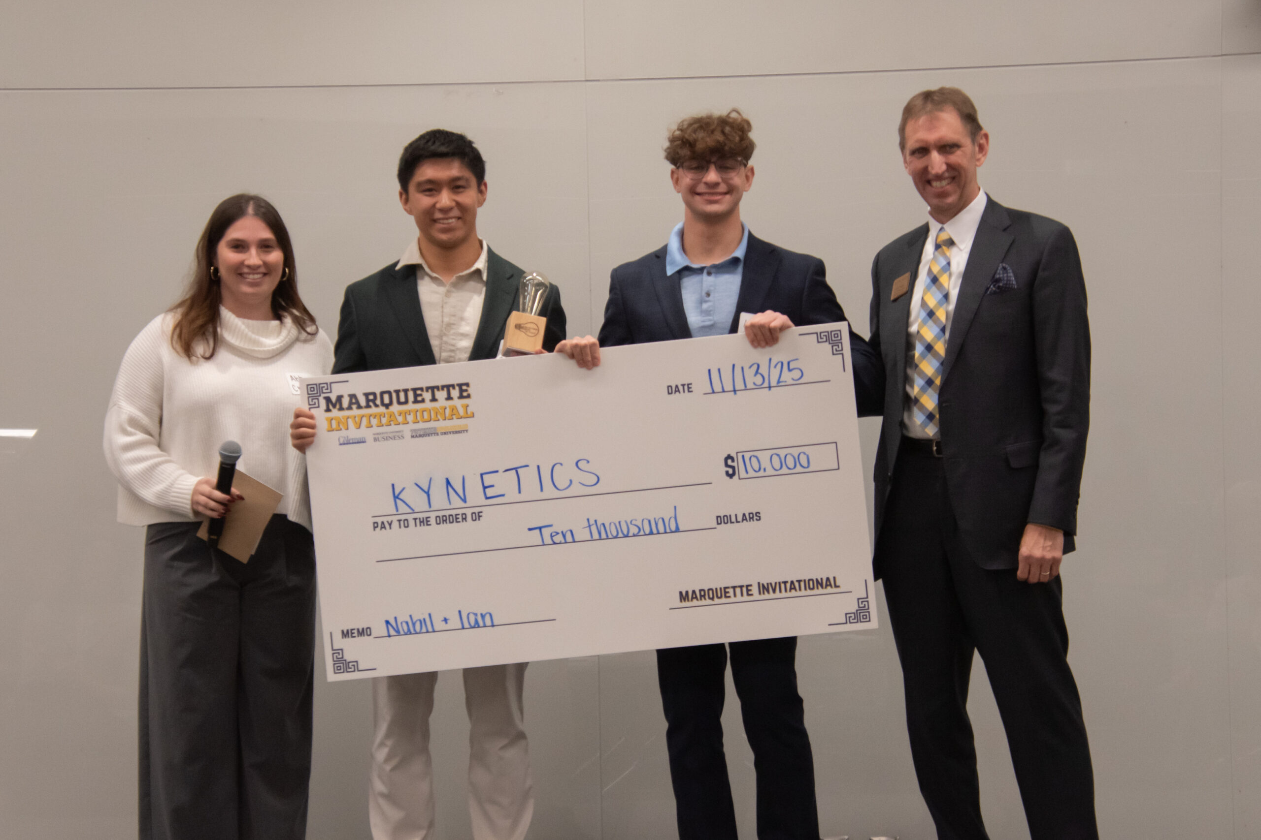 Marquette students accepting award and check at 2025 Marquette Invitational