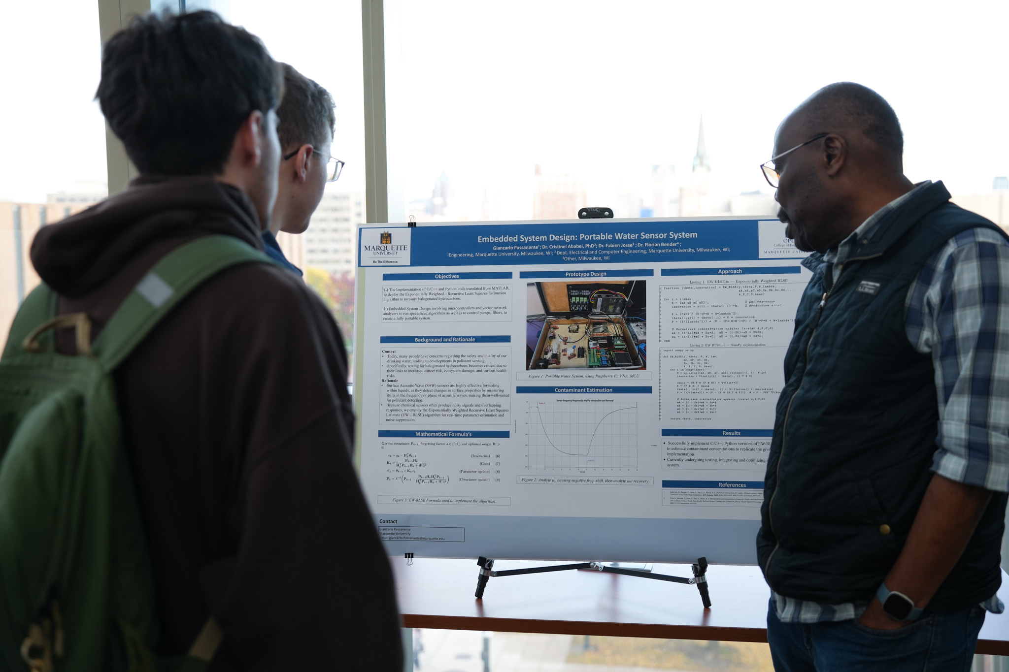 students and faculty talking in front of research poster