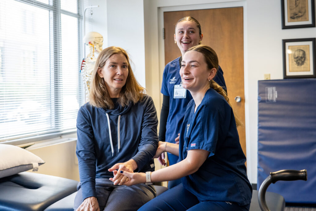 Two students perform therapy on a client. 