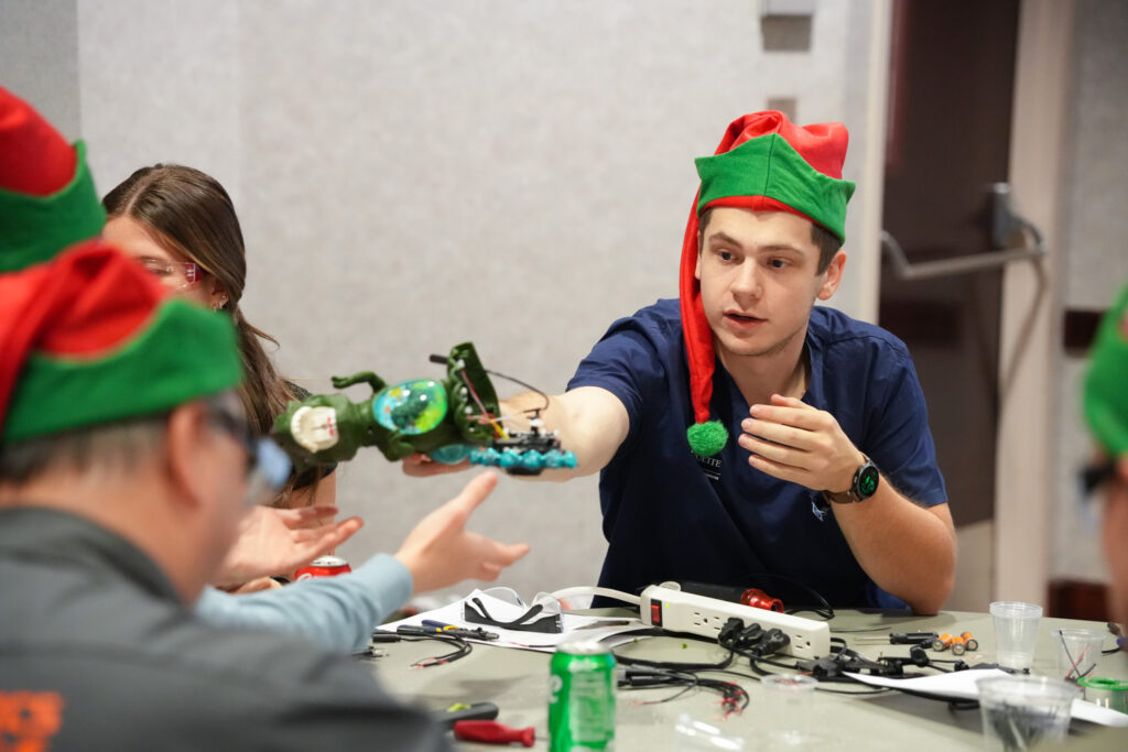 volunteers collaborating with hand tools to adapt toys