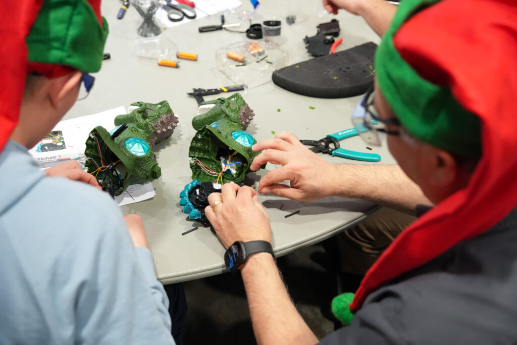 volunteers collaborating with hand tools to adapt toys