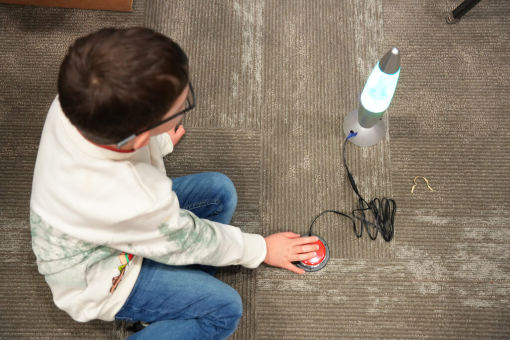 students collaborating with hand tools to adapt toys