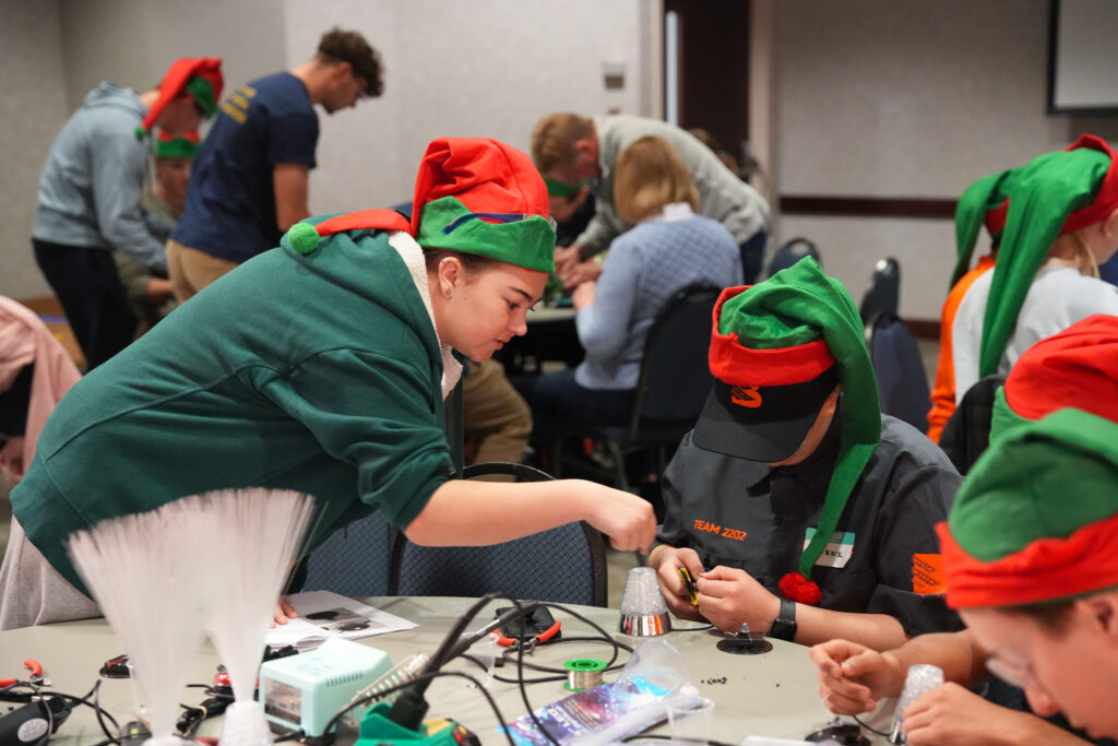 students collaborating with hand tools to adapt toys