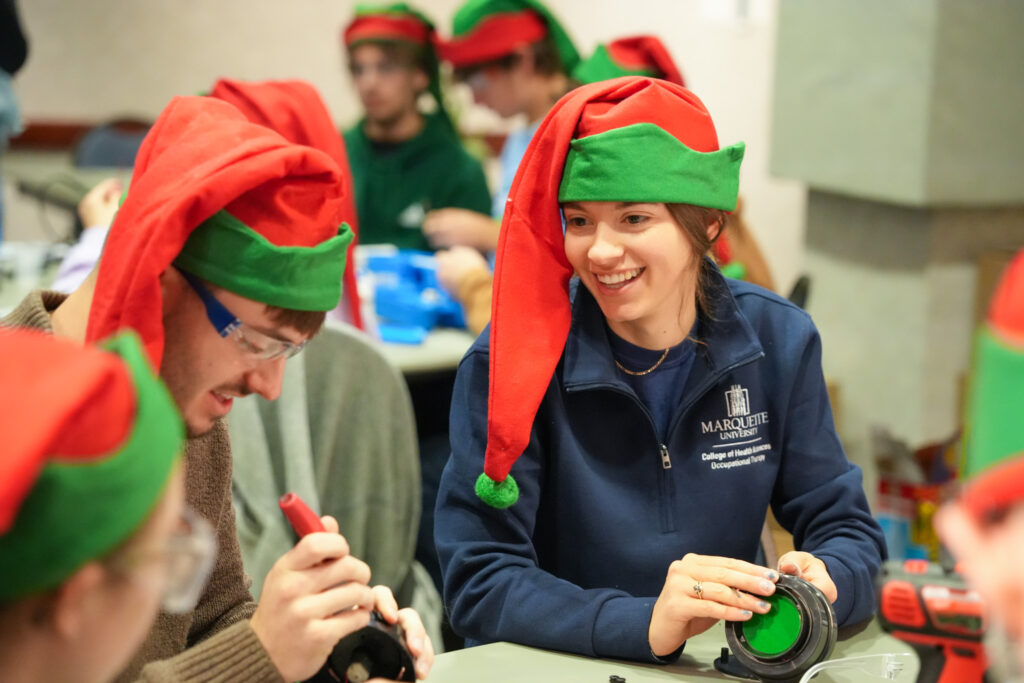 volunteers collaborating with hand tools to adapt toys