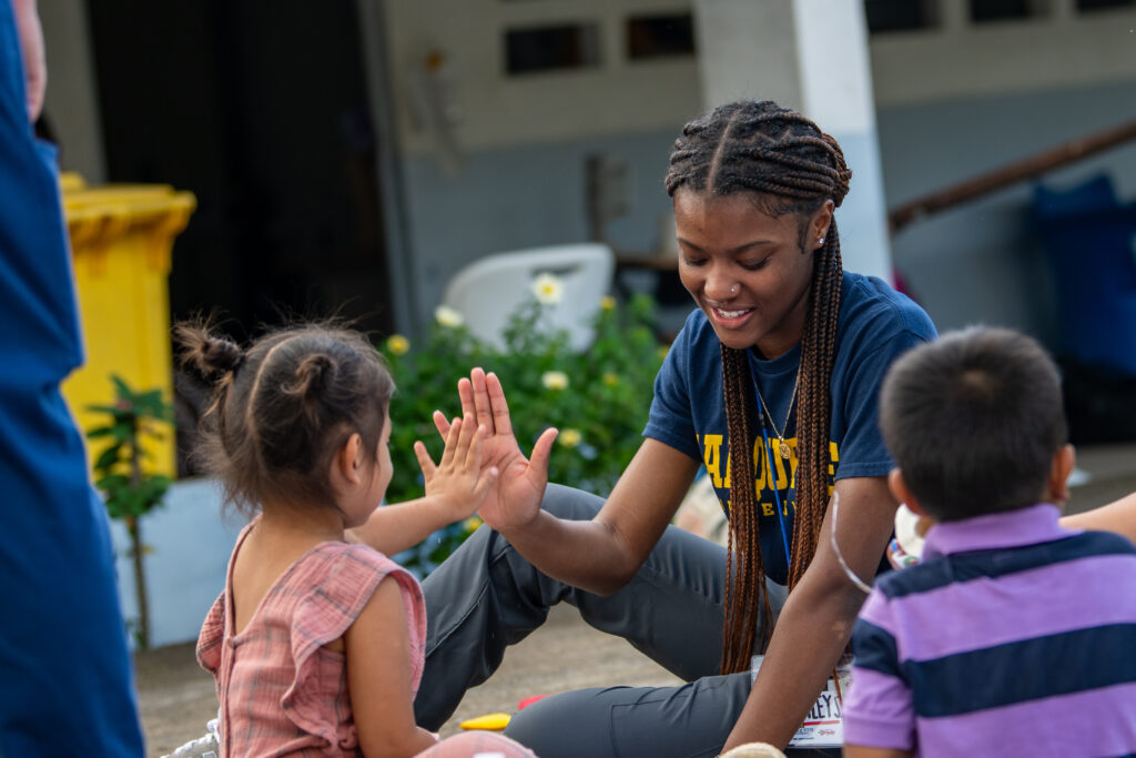 MaHailey Stephens gives a high five to a child in Panama while on Global Brigades. 