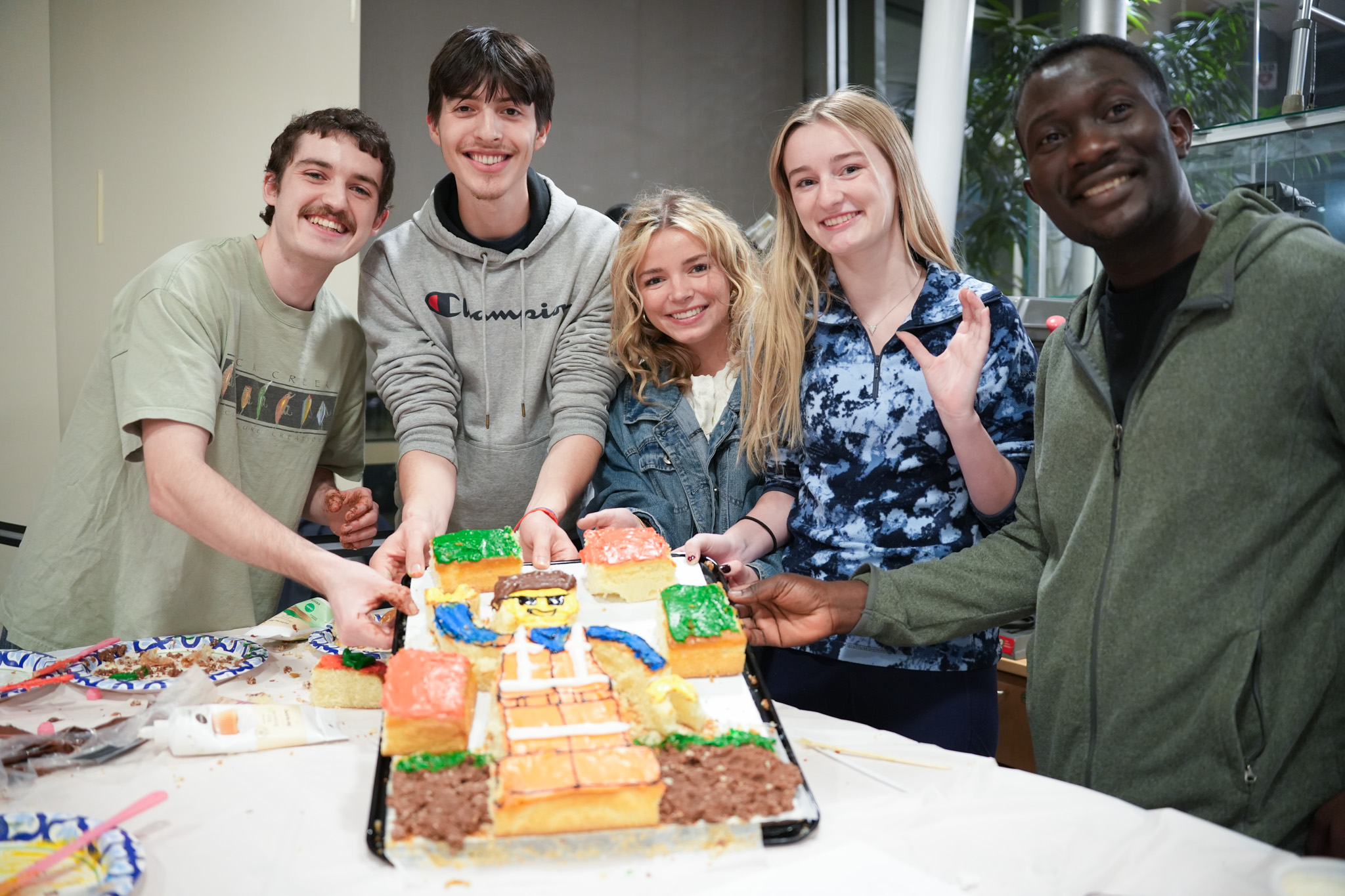 Students posing with lego cake at cake decorating contest