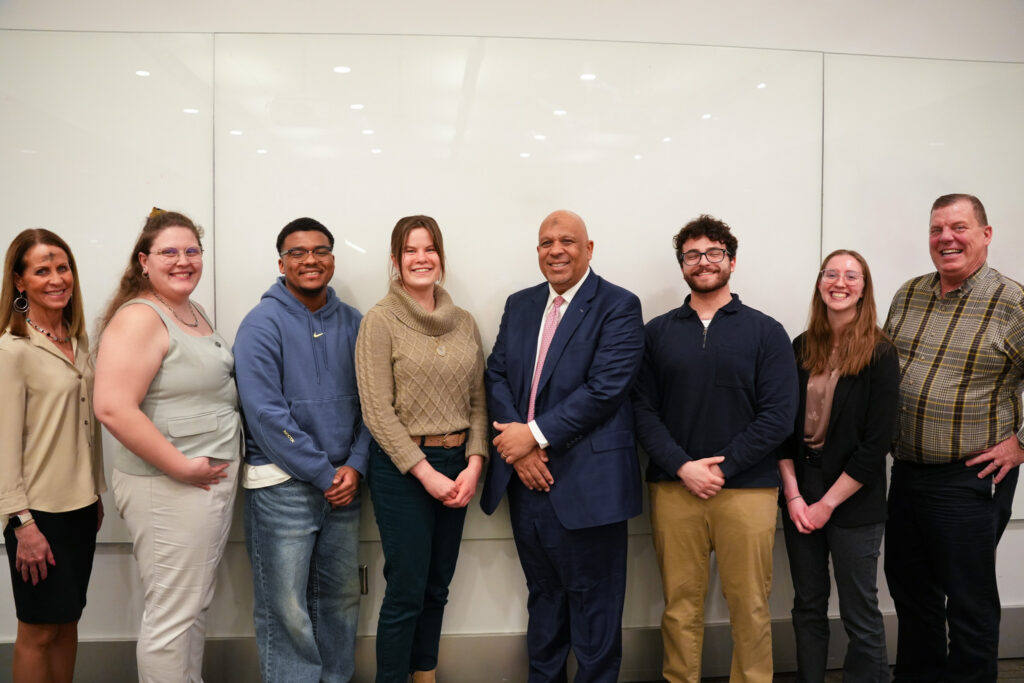President Ah Yun, Dr. Ropella and Dr. Federle posing with research students