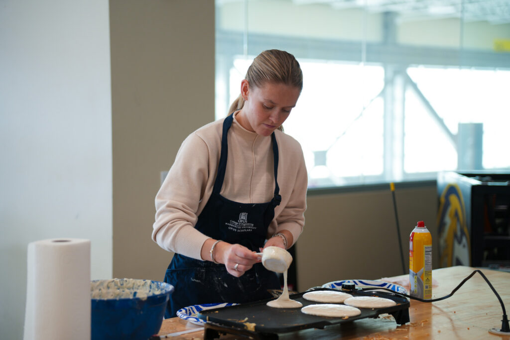 Staff in apron serving pancakes in Engineering Hall