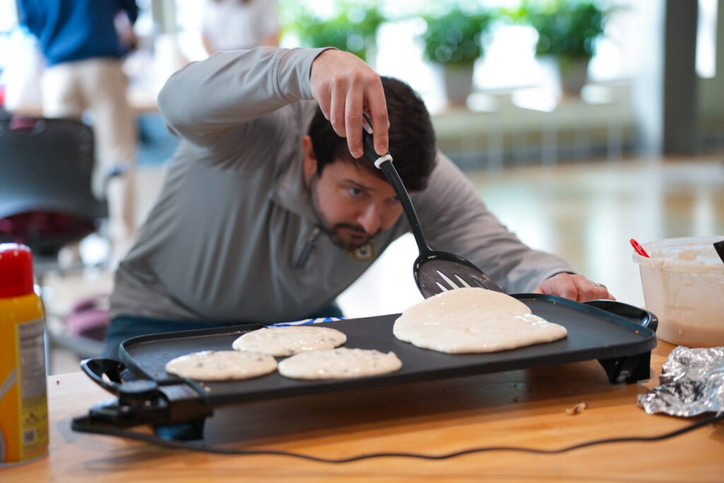 Faculty in apron serving pancakes in Engineering Hall