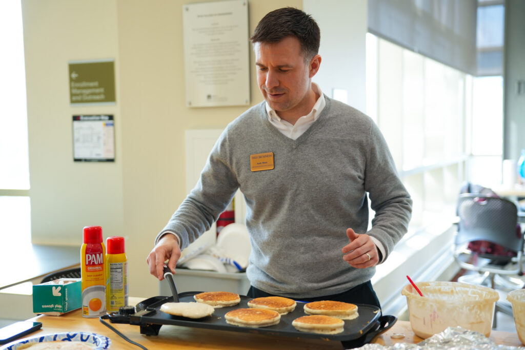 Faculty in apron serving pancakes in Engineering Hall