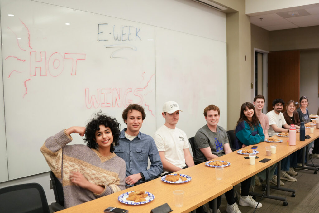 students posing at table during hot wings event