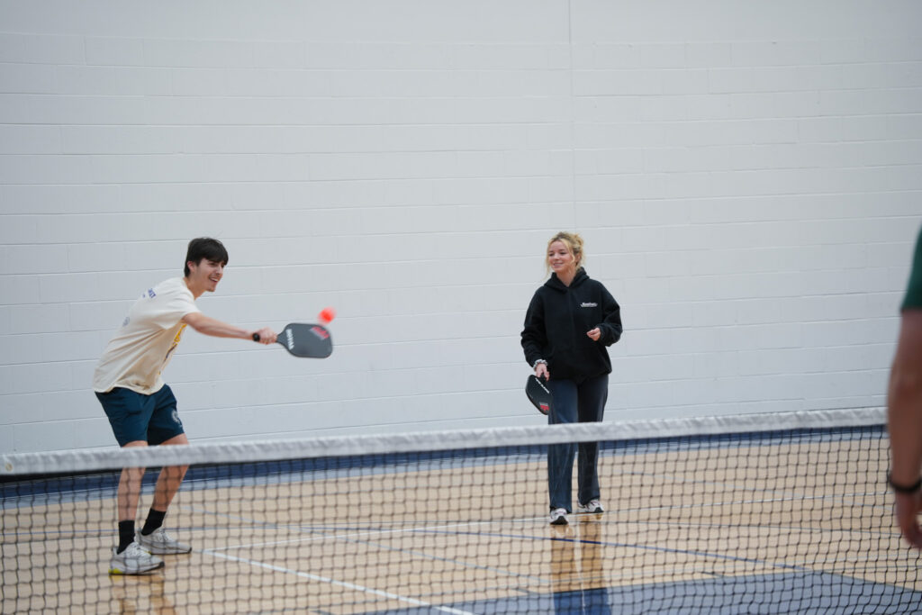 two students playing pickleball