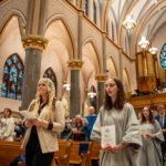 Maddie Janecek and her sponsor walking down the aisle at the Church of the Gesu