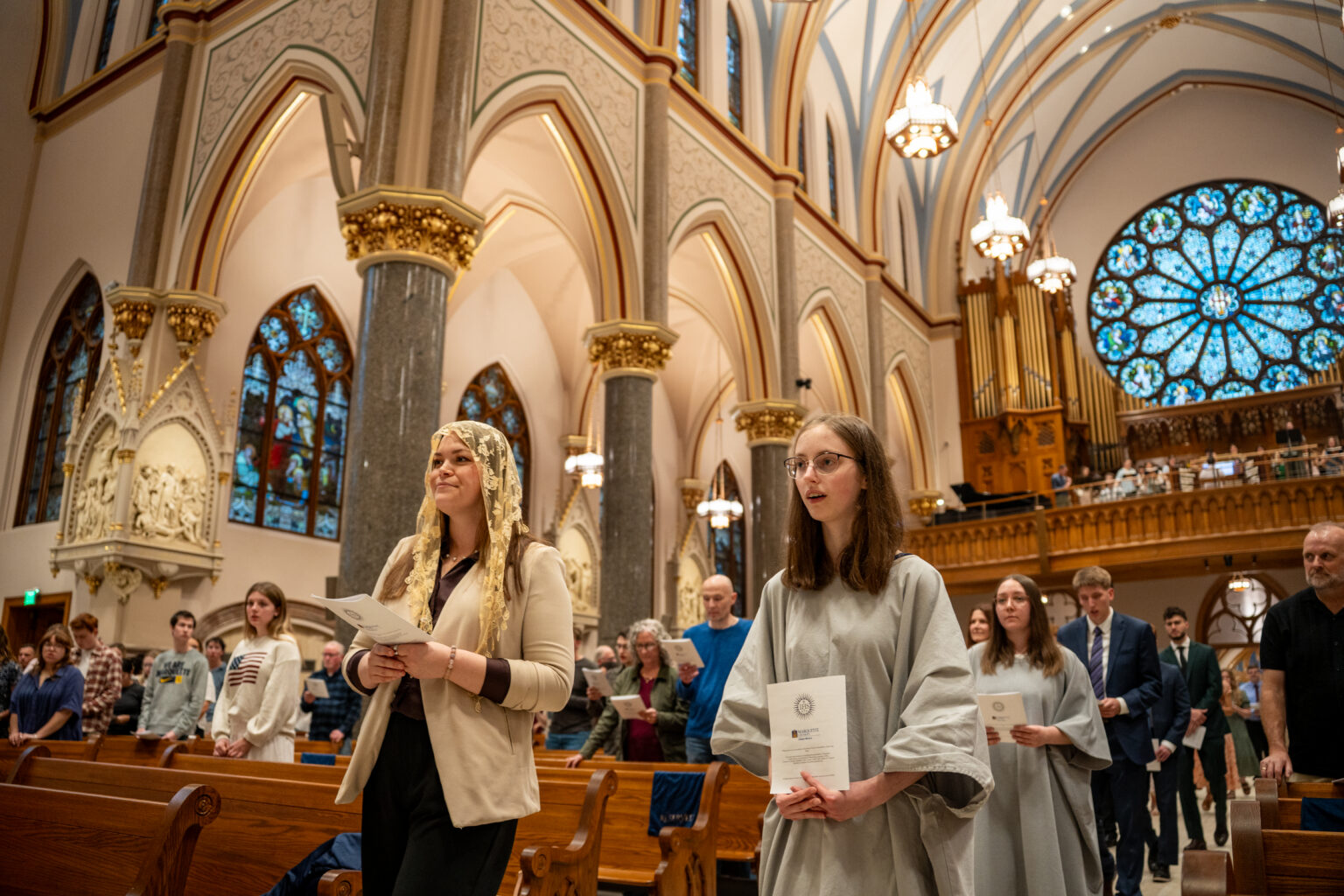 Maddie Janecek and her sponsor walking down the aisle at the Church of the Gesu