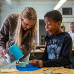 Raya Broeren conducts a science experiment with a student