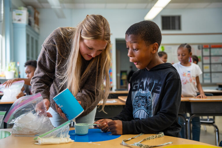 Raya Broeren conducts a science experiment with a student