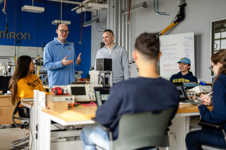 students and faculty collaborating in lab space