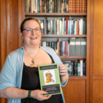 Grace Moone holds her publication featured in the Tolkien archives