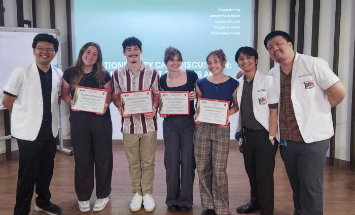 Marquette students and clinicians from Manila posing with certificates in a presentation room