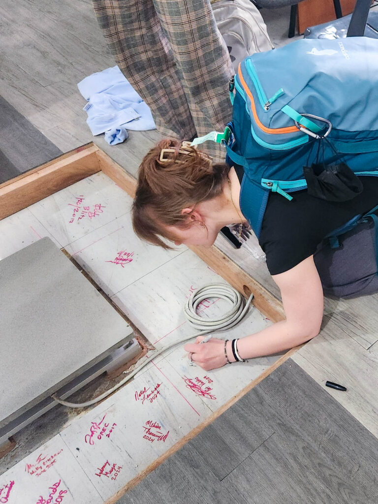 Maggie Gnorski signing her name on a force plate in a Manila clinic